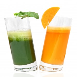 fresh juices from carrot and parsley in glasses isolated on whit