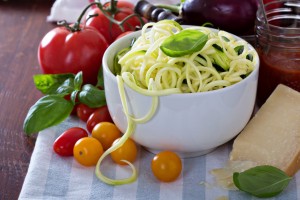 Zucchini noodles in a bowl with fresh vegetables and cheese ** Note: Shallow depth of field