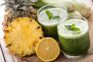 A potrait of a glass of pineapple and lettuse mix juice