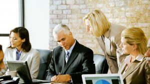 A group of business people discuss things at a meeting. ** Note: Slight blurriness, best at smaller sizes